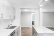 Thumbnail 12 of 26 - a kitchen with white countertops and stainless steel appliances