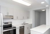 Thumbnail 8 of 26 - a kitchen with white cabinets and stainless steel appliances
