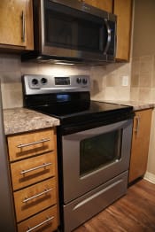 Thumbnail 12 of 54 - Kitchen cabinets with black appliances at Graymayre Crossing Apartments, Washington, 99208