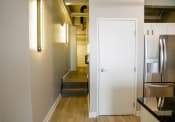 Thumbnail 29 of 82 - a hallway with a white door and a stainless steel refrigerator
