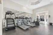 Thumbnail 32 of 34 - a gym with treadmills and other exercise equipment in a large room