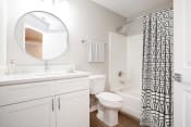 Thumbnail 12 of 33 - a bathroom with white cabinets and a black and white shower curtain