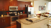Thumbnail 12 of 34 - a kitchen with a large island with granite countertops