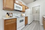 Thumbnail 4 of 34 - a kitchen with white appliances and wooden cabinets