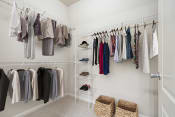 Thumbnail 6 of 34 - a closet with a rack of clothes in it and