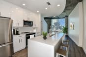 Thumbnail 1 of 34 - renovated home | kitchen with white cabinets, white quartz countertops, stainless steel appliances