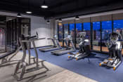 Thumbnail 26 of 40 - a workout room with treadmills and other exercise equipment at night