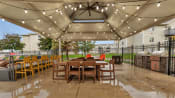 Thumbnail 9 of 12 - a patio with a table and chairs under a canopy