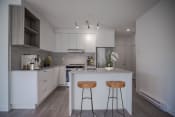 Thumbnail 5 of 21 - a kitchen with white cabinets and a white island with two wooden stools