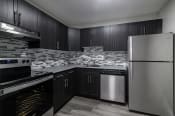 Thumbnail 15 of 20 - a black and white photo of a kitchen with black cabinets and stainless steel appliances