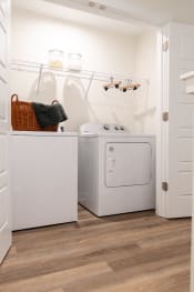 Thumbnail 1 of 8 - a white washer and dryer in a laundry room with a basket on top