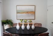 Thumbnail 7 of 19 - a dining room table with white vases and a painting on the wall