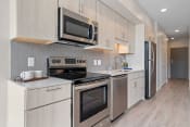 Thumbnail 47 of 59 - a kitchen with white cabinets and stainless steel appliances