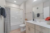 Thumbnail 58 of 59 - a bathroom with a white sink and toilet next to a white bathtub with a shower curtain