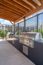 Thumbnail 33 of 59 - an outdoor kitchen with stainless steel appliances and a wooden roof