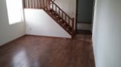 Thumbnail 8 of 18 - an empty living room with wood floors and a staircase