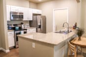 Thumbnail 23 of 55 - a kitchen with a granite counter top and a stainless steel refrigerator