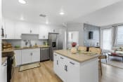 Thumbnail 37 of 50 - an open kitchen and living room with white cabinets and stainless steel appliances