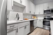 Thumbnail 14 of 22 - a kitchen with white cabinets and stainless steel appliances