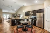 Thumbnail 11 of 11 - a kitchen and dining area with stainless steel appliances and a table