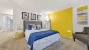 Thumbnail 6 of 28 - a bedroom with a yellow accent wall and a bed