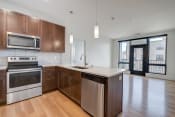 Thumbnail 11 of 36 - an empty kitchen with wooden cabinets and stainless steel appliances