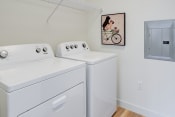 Thumbnail 9 of 36 - a washer and dryer in a laundry room with a painting on the wall