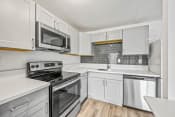 Thumbnail 28 of 42 - a kitchen with white cabinets and stainless steel appliances