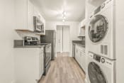Thumbnail 9 of 42 - a kitchen with white cabinetry and a washer and dryer
