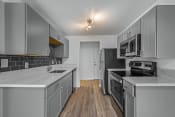 Thumbnail 38 of 42 - a kitchen with gray cabinets and white countertops