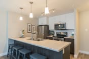 Thumbnail 16 of 18 - a kitchen with a large island and stainless steel appliances