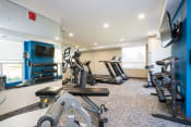 Thumbnail 7 of 18 - a gym with cardio equipment and a flat screen tv