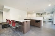 Thumbnail 6 of 18 - resident lounge white countertops and a wooden island with three red chairs
