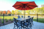 Thumbnail 9 of 18 - a patio with a table and chairs and an umbrella