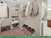 Thumbnail 8 of 58 - a walk in closet with a rack of clothes and shoes