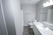 Thumbnail 11 of 11 - Bathroom with a sink toilet and mirror at Canterbury House apartments in Logansport, Indiana