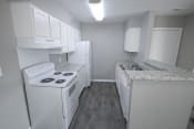 Thumbnail 3 of 11 - Kitchen with a white stove, refrigerator and sink at Canterbury House apartments in Logansport, Indiana
