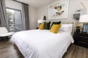 Thumbnail 14 of 18 - a bedroom with a large bed with white bedding and yellow and green pillows