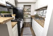 Thumbnail 11 of 18 - a kitchen with white cabinets and a black stove top oven