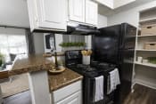 Thumbnail 13 of 18 - a kitchen with white cabinets and black appliances