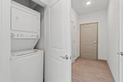Thumbnail 10 of 71 - a white laundry room with a white washer and dryer and a white doorat Metropolis Apartments, Virginia