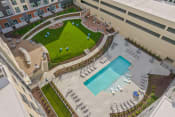 Thumbnail 45 of 71 - an aerial view of the pool and grassy area of an apartment buildingat Metropolis Apartments, Virginia