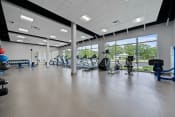 Thumbnail 38 of 71 - a gym with cardio equipment and windows on the side of a buildingat Metropolis Apartments, Glen Allen