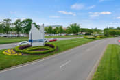 Thumbnail 59 of 71 - a street with a sign and flowers on the side of a road at Metropolis Apartments, Glen Allen Virginia