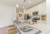 Thumbnail 3 of 40 - a white kitchen with a table with plates on it