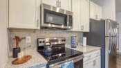 Thumbnail 25 of 53 - an updated kitchen with stainless steel appliances and granite counter tops