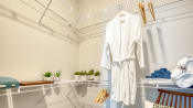 Thumbnail 29 of 53 - a white robe hanging on a rack in a closet