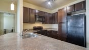 Thumbnail 4 of 22 - a kitchen with black appliances and granite counter tops