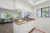 Thumbnail 52 of 100 - a kitchen with white cabinetry and a granite countertop