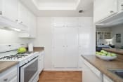 Thumbnail 60 of 100 - a kitchen with white cabinetry and a white stove top oven